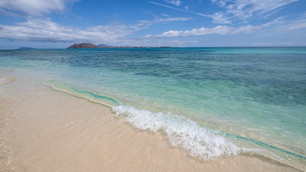 Una playa en Grandes Playas de Corralejo con vistas al islote de Lobos